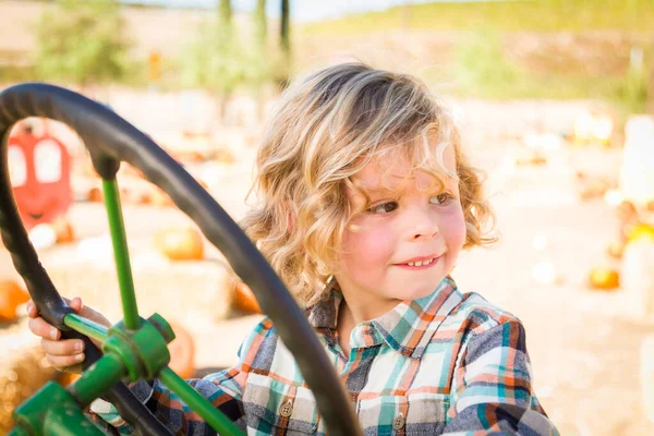 在南瓜园的乡村牧场里 小男孩在拖拉机上玩乐 — 图库照片