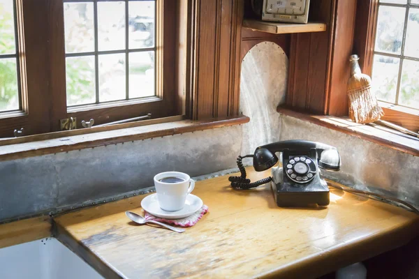 Telefone antigo e xícara de café na cozinha antiga — Fotografia de Stock