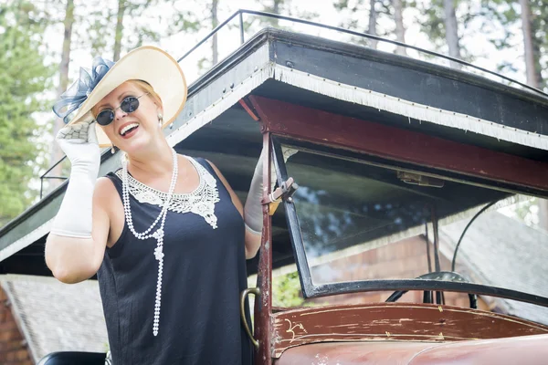 Aantrekkelijke vrouw in twintiger jaren outfit in de buurt van antieke auto — Stockfoto