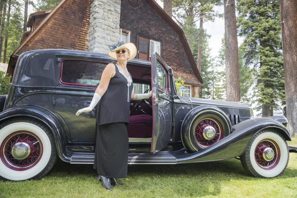 有魅力的女人，在二十年代装备附近古董汽车 — 图库照片