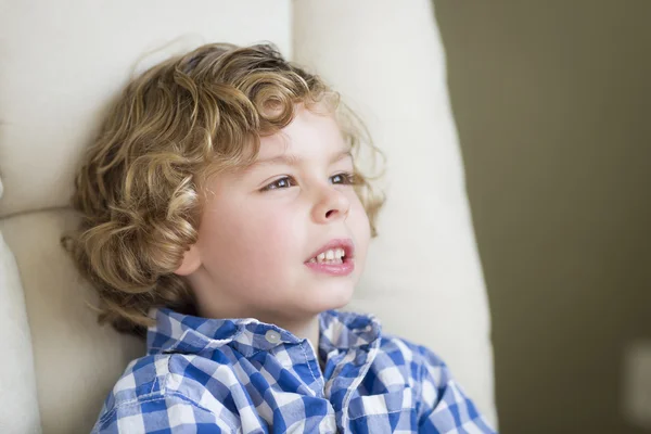 Schattige blonde jongen dagdromen en zitten in de stoel — Stockfoto