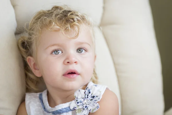 Adorable rubia peludo y azul de ojos niña en silla — Foto de Stock