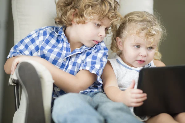 Joven hermano y hermana usando su computadora portátil juntos — Foto de Stock
