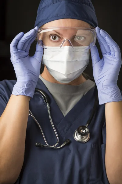 Kvinnliga läkare eller sjuksköterska att sätta på ansiktsbehandling skyddskläder — Stockfoto
