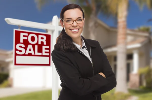 Jeune femme devant la maison et signe de vente — Photo