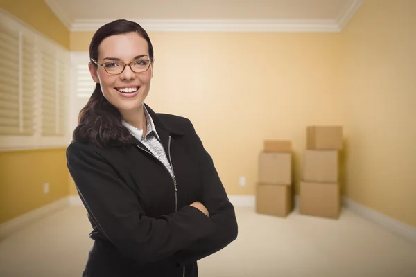 Mujer de raza mixta en habitación vacía con cajas —  Fotos de Stock