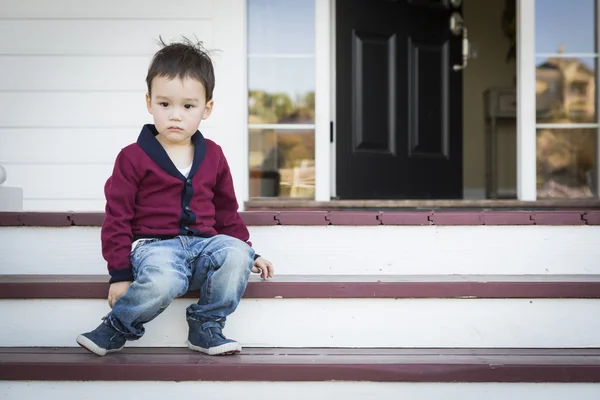 Melancolia mista raça menino sentado na varanda da frente Passos — Fotografia de Stock