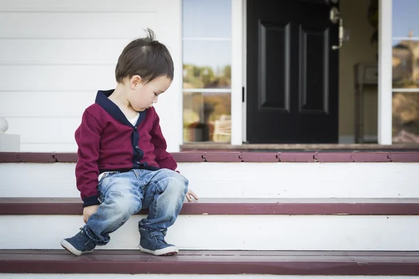 Melancholické smíšené rasy chlapec sedí na verandě kroků — Stock fotografie