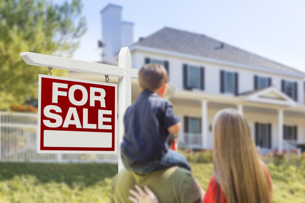 Family Facing For Sale Real Estate Sign and House