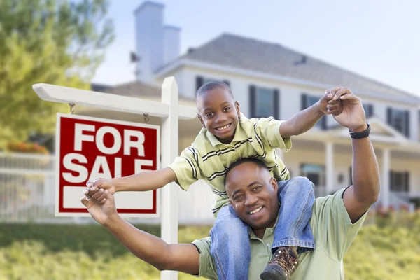 Padre e hijo afroamericanos, letrero de venta y hogar — Foto de Stock