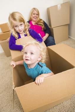 Boş odada hareketli kutular ile oynayan genç aile