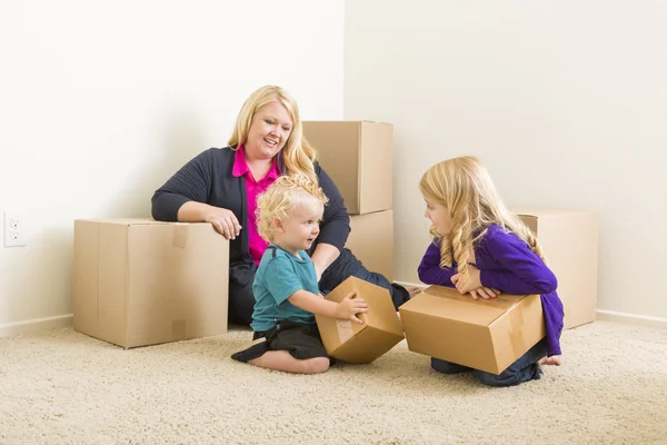 Familia joven en habitación vacía con cajas móviles —  Fotos de Stock