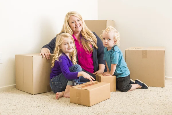 Jovem família em quarto vazio com caixas móveis — Fotografia de Stock