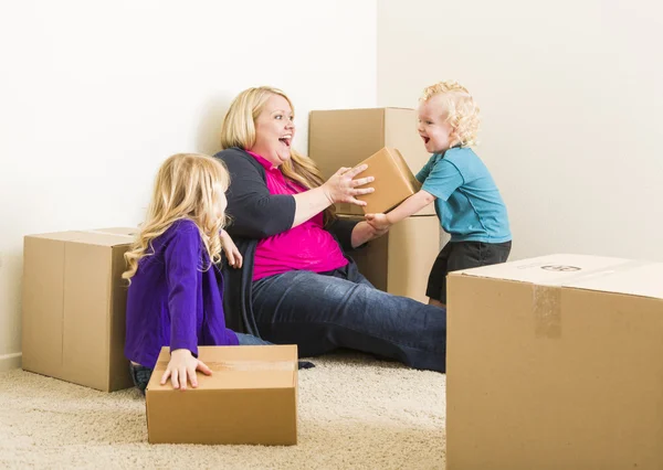 Young Family In Empty Room Playing With Moving Boxes — Stock Photo, Image