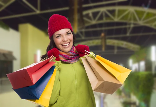 Quente vestido misto raça mulher com sacos de compras — Fotografia de Stock