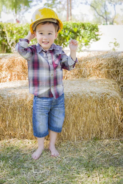 Молодой смешанный расовый мальчик смеется с жесткой шляпой снаружи — стоковое фото