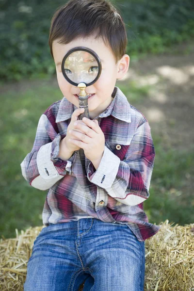 Lindo joven mixto raza chico buscando a través de lupa — Foto de Stock