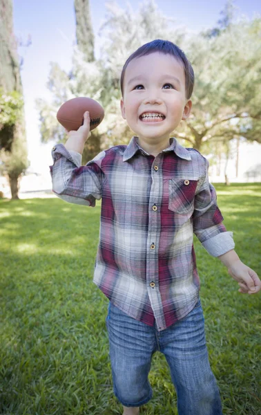 Roztomilý mladý smíšené rasy Boy hrát fotbal mimo — Stock fotografie