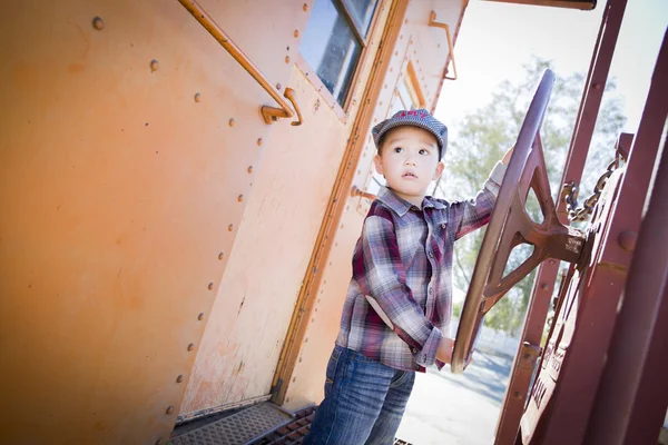 Niedliche junge gemischte Rasse Junge mit Spaß auf Eisenbahnwagen — Stockfoto