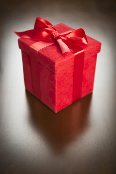 Red Gift Box with Ribbon and Bow Resting on Wood — Stock Photo, Image