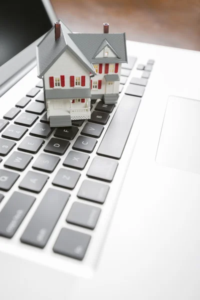 Casa em miniatura no computador portátil — Fotografia de Stock