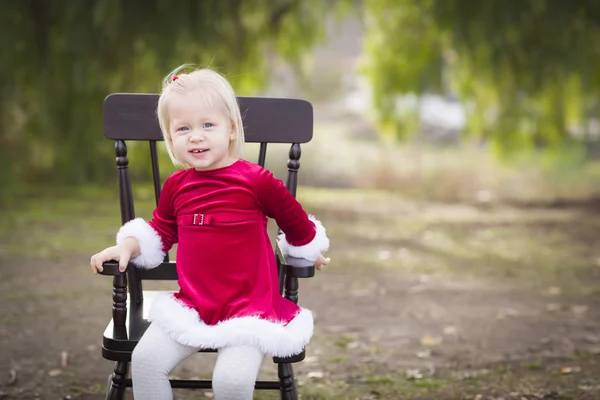 Bedårande liten flicka sitter i sin stol utanför — Stockfoto