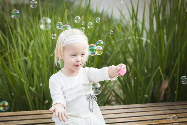 Adorável menina se divertindo com bolhas — Fotografia de Stock