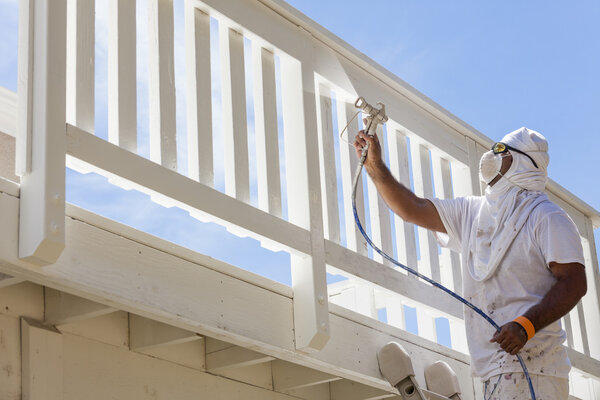 House Painter Spray Painting A Deck of A Home