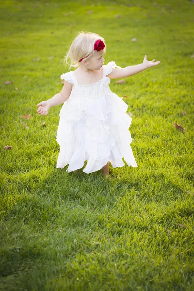 Αξιολάτρευτο κοριτσάκι που φοράει λευκό φόρεμα σε ένα πεδίο χλόης — Φωτογραφία Αρχείου