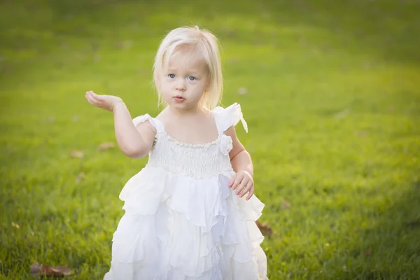 Adorável menina vestindo vestido branco em um campo de grama — Fotografia de Stock