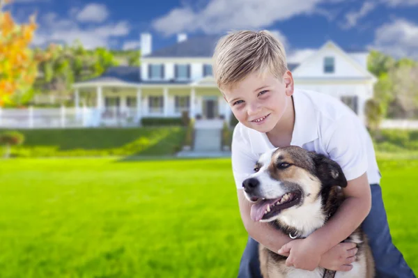 Joven chico y su perro en frente de casa — Foto de Stock