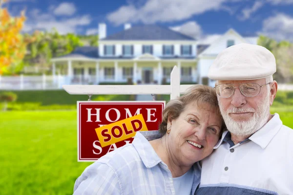 Senior Couple in Front of Sold Real Estate Sign and House — Stock Photo, Image