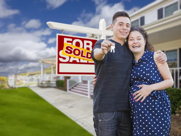 Hispanic paar met toetsen vooraan huis en teken — Stockfoto