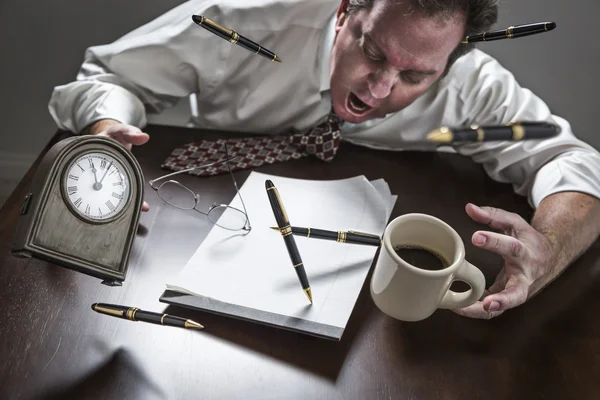 Homem estressado na mesa, Canetas, Café, óculos, Relógio voando — Fotografia de Stock