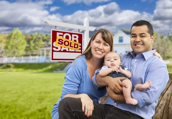 Jonge gezin voor verkocht onroerend goed teken en huis — Stockfoto