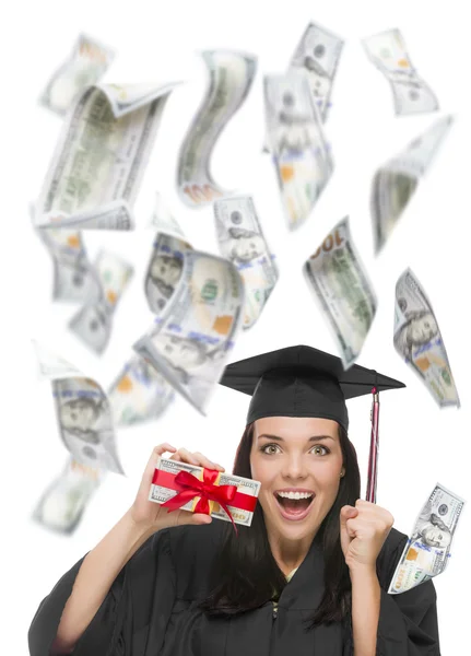 Graduada feminina segurando cem dólares com muitos caindo em torno dela — Fotografia de Stock