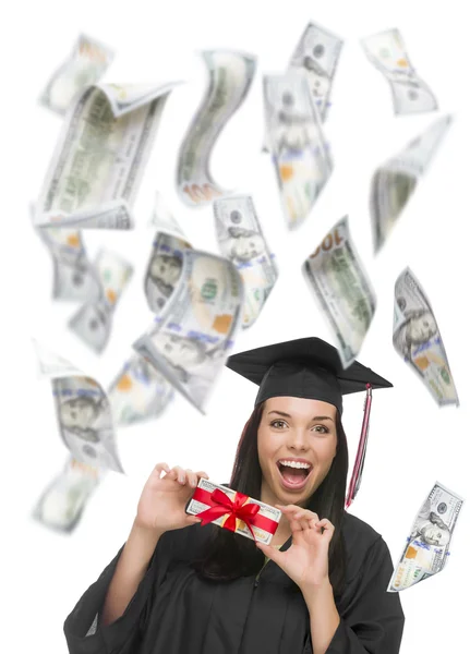 Graduada feminina segurando cem dólares com muitos caindo em torno dela — Fotografia de Stock