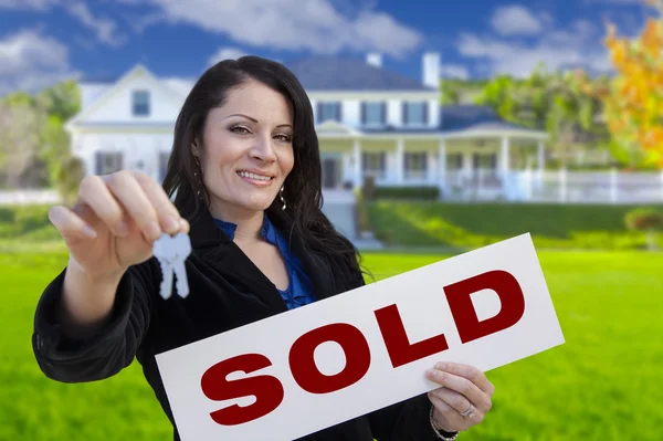 Woman Holding Sold Sign and Keys In Front of House Royalty Free Stock Images