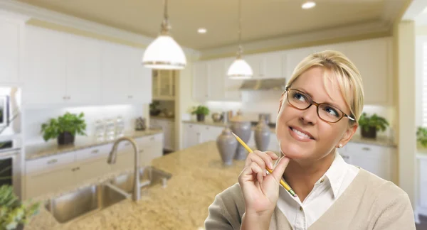 Tagträumende Frau mit Bleistift in schöner Küche — Stockfoto