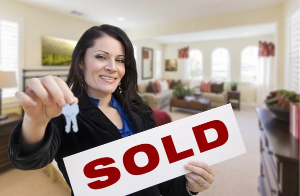 Hispanic Woman with Keys and Sold Sign in Living Room Stock Picture