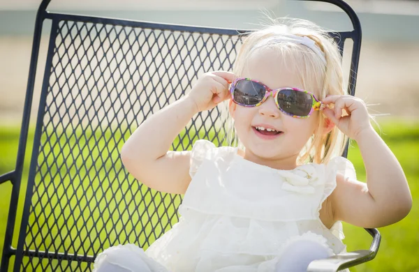 Bonito brincalhão bebê menina vestindo óculos de sol fora no parque — Fotografia de Stock