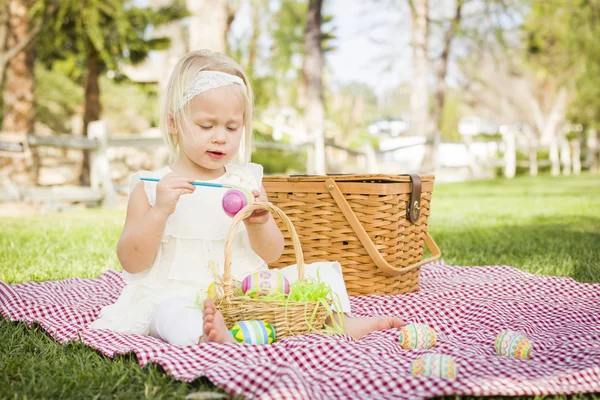 Linda niña para colorear huevos de Pascua en la manta de picnic —  Fotos de Stock