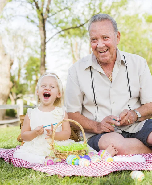 Grandfather and Granddaughter Coloring Easter Eggs on Blanket At Royalty Free Stock Photos