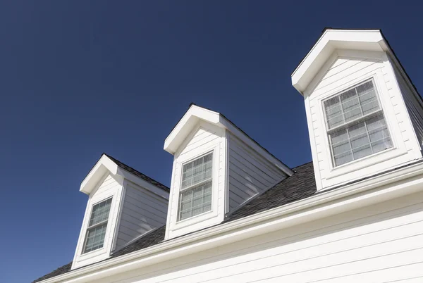 Telhado de casa e janelas contra céu azul profundo — Fotografia de Stock
