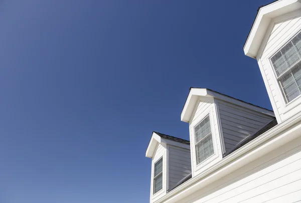 Telhado de casa e janelas contra céu azul profundo — Fotografia de Stock