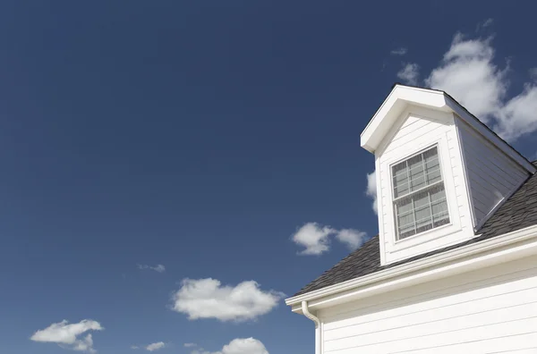 Telhado de casa e janelas contra céu azul profundo — Fotografia de Stock