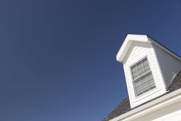 Telhado de casa e janelas contra céu azul profundo — Fotografia de Stock