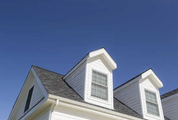 Roof of House and Windows Against Deep Blue Sky Stock Photo