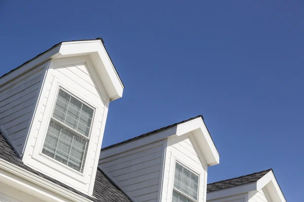 Roof of House and Windows Against Deep Blue Sky Stock Image