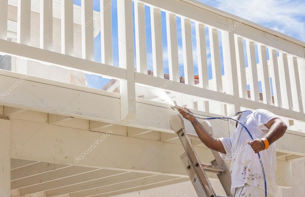 House Painter Spray Painting A Deck of A Home